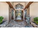 Elegant front entrance with custom doors and stone accents at 663 Turnberry Ct, Tarpon Springs, FL 34688