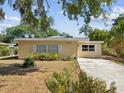 Welcoming single-story home with a concrete driveway and a cozy, well-lit entryway at 7012 Ponderosa Dr, Tampa, FL 33637