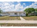 Charming single-story home with a covered carport, neatly kept lawn, and neutral color scheme at 7050 Merrick Ln, Spring Hill, FL 34606