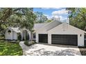 Traditional home with a two-car garage and lush landscaping at 7233 Royal Oak Dr, Spring Hill, FL 34607