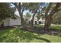Traditional home featuring well-maintained landscaping and mature trees at 7233 Royal Oak Dr, Spring Hill, FL 34607