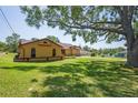 Expansive backyard featuring lush green lawn and mature trees providing shade and privacy at 7270 Nightwalker Rd, Weeki Wachee, FL 34613
