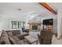 Spacious living room with a stone fireplace, plush seating, and a large TV at 7270 Nightwalker Rd, Weeki Wachee, FL 34613