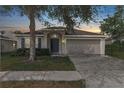 Charming single-story home with a two-car garage during sunset at 779 Nodding Shade Dr, Brooksville, FL 34604