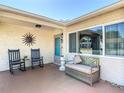 Inviting front porch with comfortable seating and a decorative sunburst wall hanging, perfect for relaxing at 8600 N Briar Patch Dr, Port Richey, FL 34668