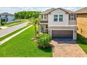 Beautiful home showcasing a well-kept lawn, palm trees, and a driveway leading to a two-car garage at 8630 Campus Woods Way, New Port Richey, FL 34655