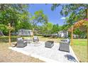 Backyard patio featuring stone pavers, fire pit, outdoor seating, and lush landscaping at 9226 Dan Lynn St, Brooksville, FL 34601