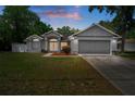 Charming single-story home featuring a two-car garage, well-maintained lawn, and lovely landscaping at 11353 Norvell Rd, Spring Hill, FL 34608