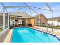 Enjoy this beautiful screened-in pool with tile trim, a grill, outdoor furniture, and a well-maintained patio at 12040 Penzance Ln, New Port Richey, FL 34654