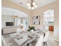 Open-concept dining area with marble-top table, modern chandelier, and seamless flow to the living spaces at 13618 Niti Dr, Hudson, FL 34669