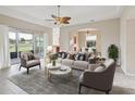 Cozy living room with neutral tones, plush seating, and a view of the backyard at 13618 Niti Dr, Hudson, FL 34669