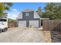 Close-up of the detached two-car garage and workshop featuring white doors and a well-maintained exterior at 14545 Battenwood Dr, Spring Hill, FL 34610