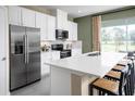 Bright, modern kitchen featuring white cabinets, stainless steel appliances, and a large island with seating at 20385 Lou Angela Ln, Lutz, FL 33558