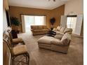 Spacious living room with neutral carpet, ample seating, and sliding glass doors to the outdoor patio area at 21008 Sunpoint Way # 204, Lutz, FL 33558