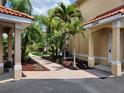 Beautifully landscaped home with brick walkway, mature palm trees, and well-maintained lawn at 21041 Sunpoint Way # 202, Lutz, FL 33558