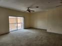 Spacious living room featuring sliding glass doors, carpet floors, and a ceiling fan at 21041 Sunpoint Way # 202, Lutz, FL 33558