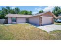 Charming single-Gathering home features a two-car garage with stone accents and a well-manicured front lawn at 2660 Orangewood Ct, Palm Harbor, FL 34684