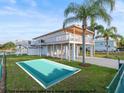 Beautiful waterfront home featuring a large deck, lush lawn, and mock pool on a sunny day at 3340 Oleander Dr, Hernando Beach, FL 34607