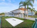 Beautiful waterfront home featuring a large deck, lush lawn, and mock pool sketch on a sunny day at 3340 Oleander Dr, Hernando Beach, FL 34607