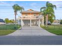 Elevated waterfront home featuring spacious driveway, ample parking, and inviting facade at 3340 Oleander Dr, Hernando Beach, FL 34607