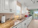 Gourmet kitchen featuring granite countertops, stainless steel sink, and white cabinets at 3340 Oleander Dr, Hernando Beach, FL 34607