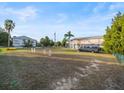 Expansive front yard with lush green grass, agility training equipment, a parked van, and a charming house in the background at 3340 Oleander, Hernando Beach, FL 34607