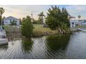 Picturesque waterfront view showcasing lush greenery meeting calm waters under a serene sky at 3340 Oleander, Hernando Beach, FL 34607