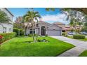 Beautiful single-story home featuring lush landscaping, a spacious two-car garage, and a well-maintained lawn at 4207 Fishermans Lake Dr, Lutz, FL 33558