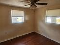 Bright bedroom featuring hardwood floors, ceiling fan, and natural light at 4534 Irene Loop, New Port Richey, FL 34652