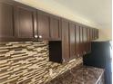 Modern kitchen with stylish backsplash, dark cabinets, and updated countertops at 4534 Irene Loop, New Port Richey, FL 34652