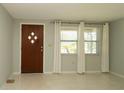 Bright living room with terrazzo floors, a front door with diamond accents, and a large window at 5018 Sherwood Dr, New Port Richey, FL 34652