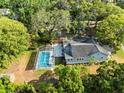 Beautiful aerial view of home with a screened-in pool, surrounded by mature trees at 606 Howell Ave, Brooksville, FL 34601