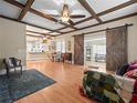 Bright living room features wood floors, beamed ceilings and sliding barn doors at 606 Howell Ave, Brooksville, FL 34601