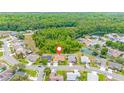 Aerial view showcases the property's location in a neighborhood with ponds and wooded areas at 7827 Starfire Way, New Port Richey, FL 34654