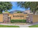 Attractive Rosewood community sign with decorative stone pillars and well-maintained landscaping at 7827 Starfire Way, New Port Richey, FL 34654