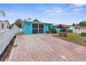 Turquoise home with a brick driveway and a well at 9015 Mark Twain Ln, Port Richey, FL 34668