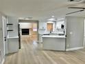 Open-concept kitchen featuring white cabinets, stainless appliances, and hardwood floors at 9034 Cochise Ln, Port Richey, FL 34668