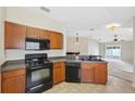 Well-equipped kitchen with dark appliances, ample counter space, and open view to the living area at 9048 Southern Charm Cir, Brooksville, FL 34613