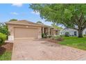 A charming single-story home with brick driveway and a well-manicured lawn at 9245 Grand Cypress Dr, Spring Hill, FL 34613