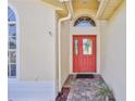 Close-up of the vibrant red front door with decorative glass and a tiled entryway at 1032 Walnut Hill Ct, Spring Hill, FL 34609