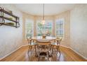 Charming dining room featuring a round table, four chairs, hardwood floors and a bay window with shutters at 1053 Winding Willow Dr, Trinity, FL 34655