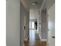 Bright hallway featuring hardwood floors and a modern chandelier light fixture at 10906 Carnelian Ln, Riverview, FL 33578