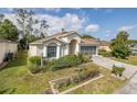 Inviting one-story home with manicured lawn, lush landscaping, and a screened two-car garage at 10906 New Brighton Ct, New Port Richey, FL 34654