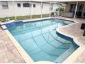 Private screened-in pool with blue tile accents and brick patio area, perfect for outdoor entertaining at 1121 Riveredge Dr, Tarpon Springs, FL 34689