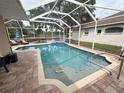 Relaxing screened-in pool area with outdoor seating, hot tub, and serene lake view at 1121 Riveredge Dr, Tarpon Springs, FL 34689