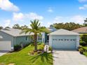 Charming single-story home with well-manicured lawn, palm tree, and an attached two-car garage at 11342 Hollander Ave, Hudson, FL 34667