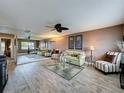 Bright living room featuring a full wall mirror, ceiling fan, and stylish furnishings at 11601 Bayonet Ln # 163A2, New Port Richey, FL 34654