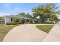 Long driveway leading to a well-maintained home with mature trees and landscaping at 12407 Gunstock Ln, Hudson, FL 34667