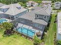 Aerial view of the backyard featuring a screened-in pool, patio furniture, and well-maintained lawn at 12539 Wetmore Ct, Odessa, FL 33556