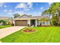 Charming single-story home with well-manicured lawn, mature trees and attached two car garage at 13039 Topflite Ct, Hudson, FL 34669